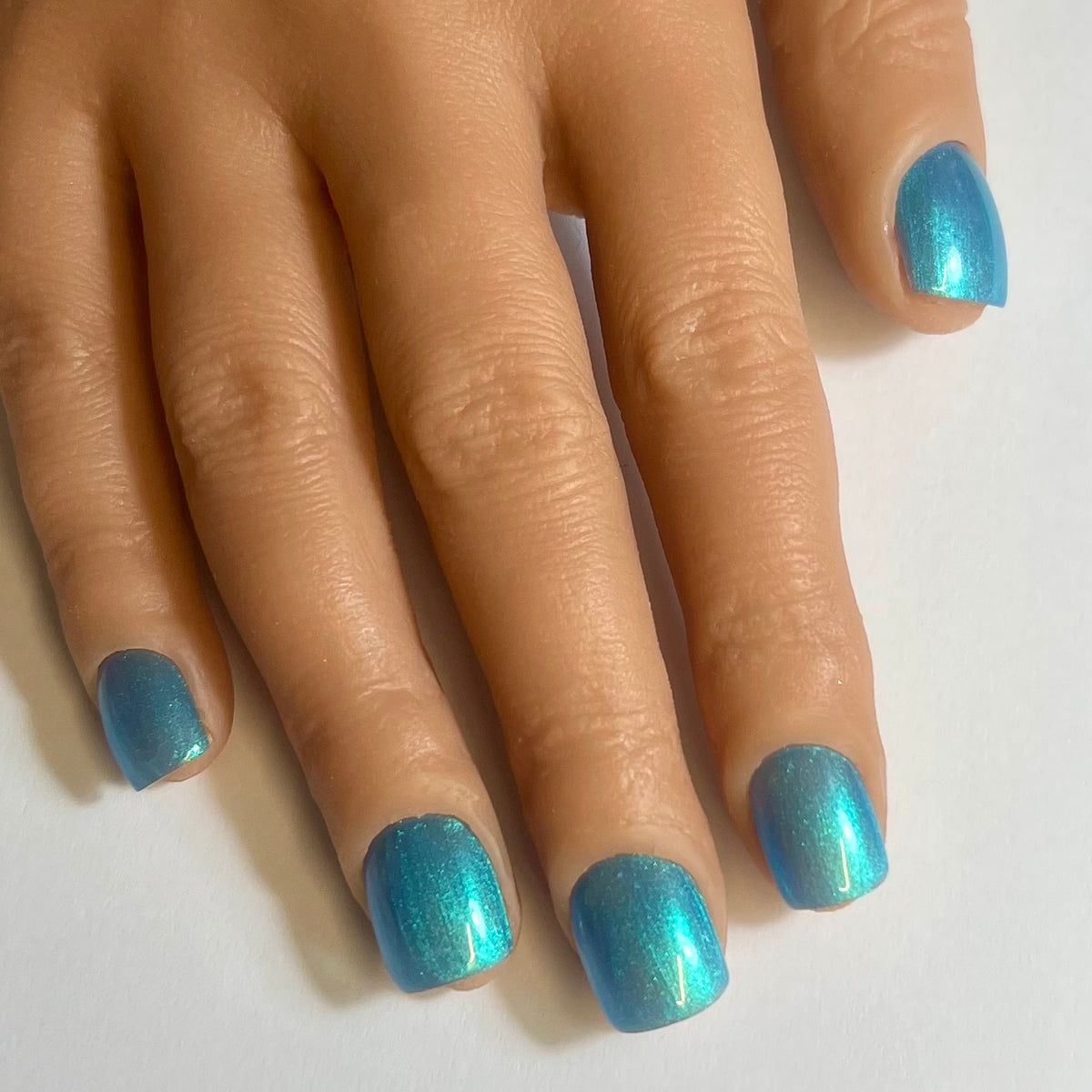 Press On Nails Kokoha modèle 016 carré court bleu irisé à reflets portés sur les ongles