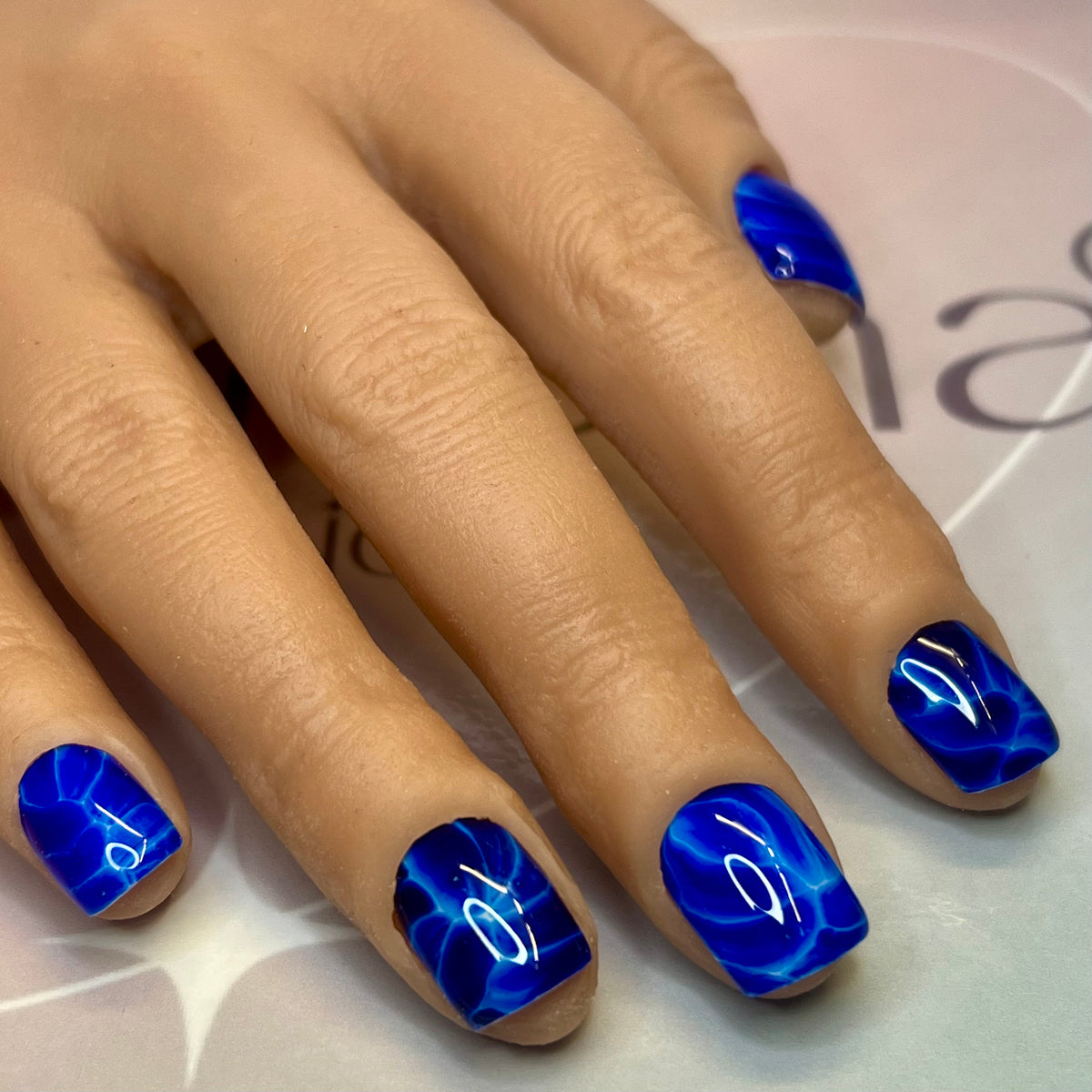 Gros plan de l’effet éclair bleu électrique sur base blanche des Fast Nails F011