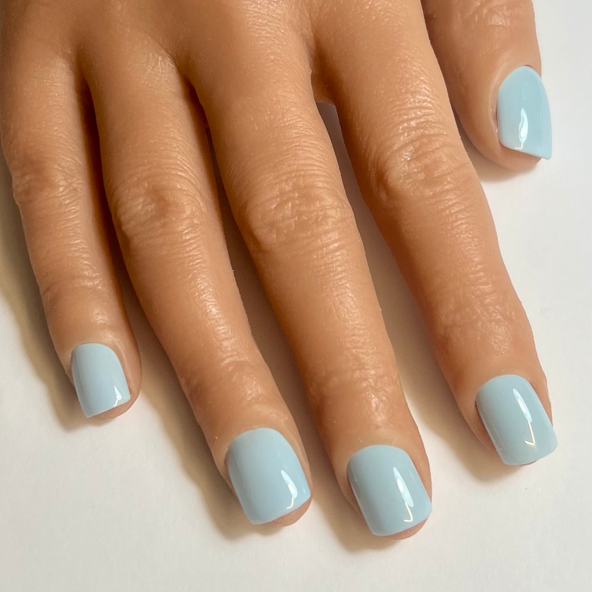 Press On Nails Kokoha modèle 008 carré court bleu ciel portés sur les ongles